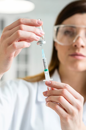 female doctor pulling serum into a syringe