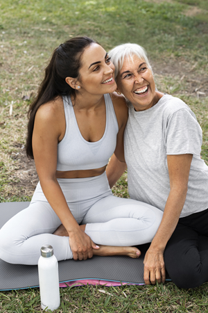 two women outside on a yoga mat