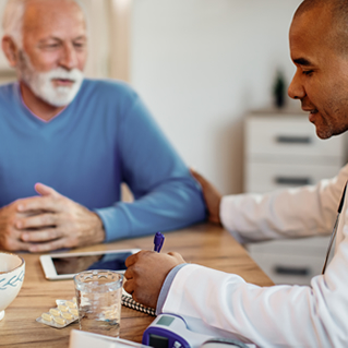male pharmacist speaking with an older male patient