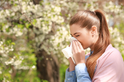 woman sneezing outdoors